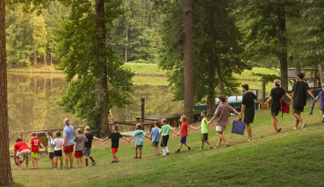 Campers holding hands going to campfire