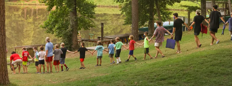 Campers holding hands going to campfire